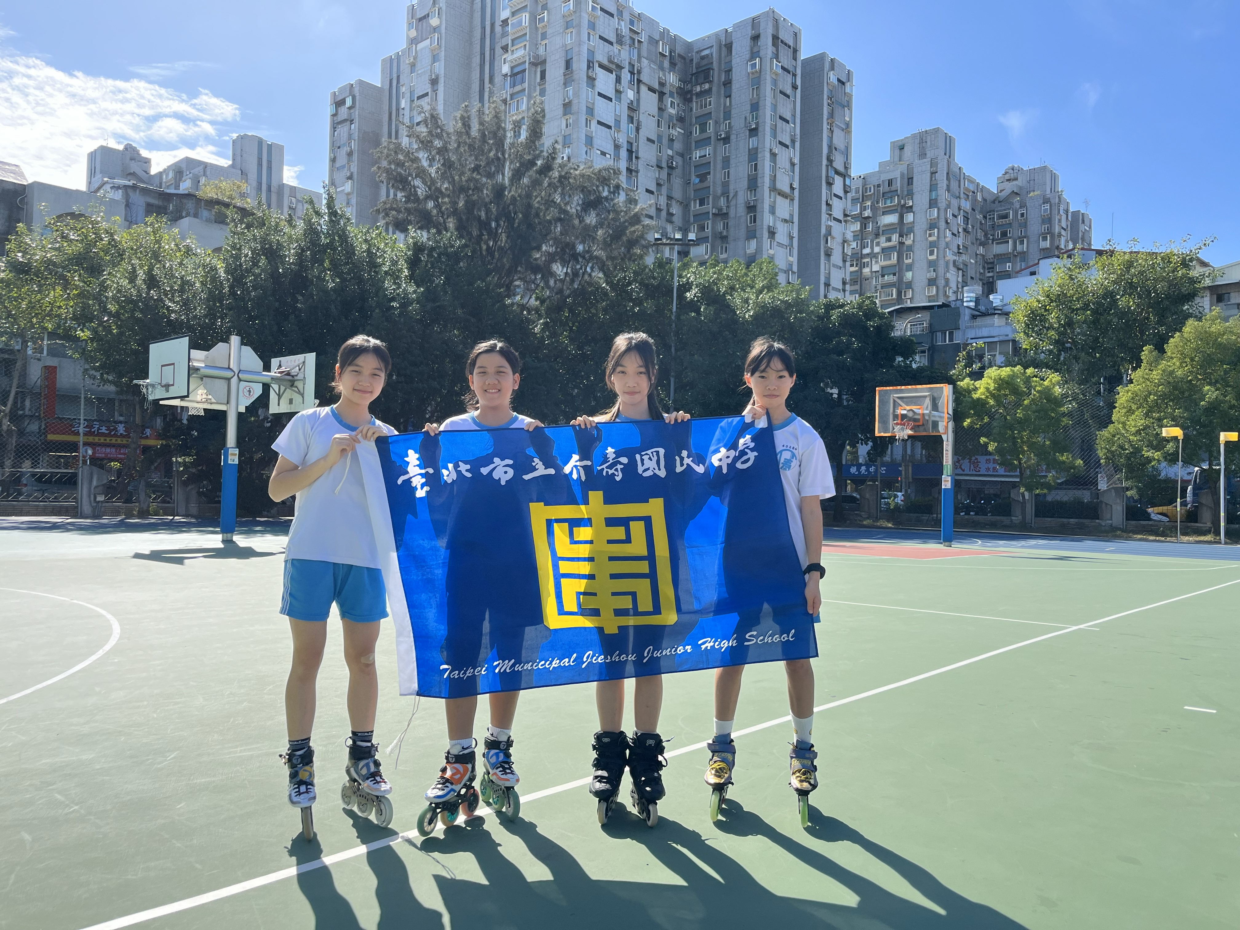 溜冰選手們舉校旗團體攝影
